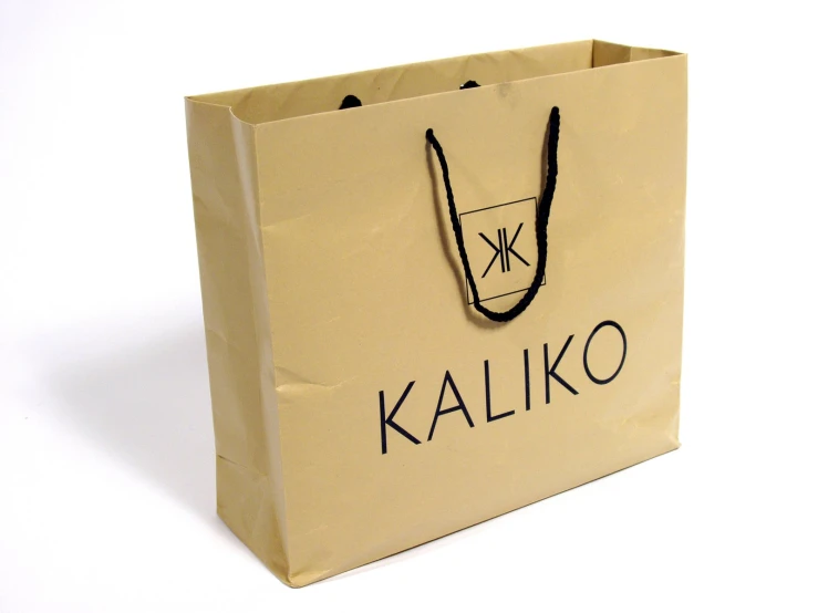 a tan paper bag with a black logo