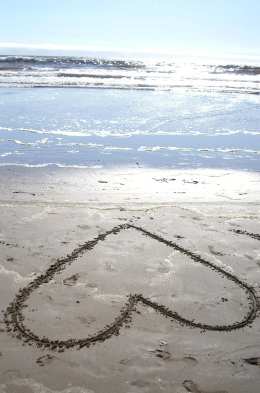 a drawing of an air - contour is drawn in the sand by the ocean