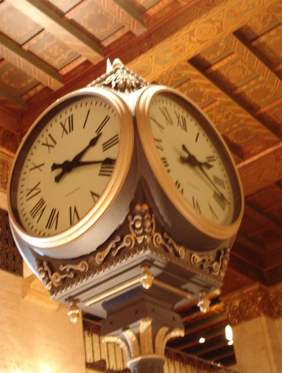 a clock inside of a building with a ceiling in the background