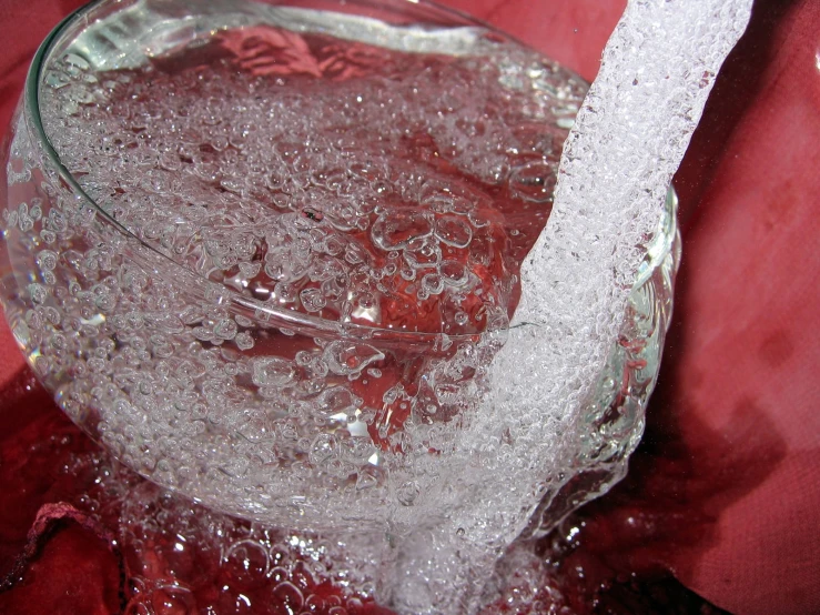 a clear bowl with ice inside on a red table cloth