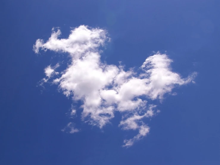 a large white cloud floating through a blue sky