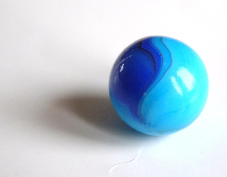 a blue and white marble ball on a table