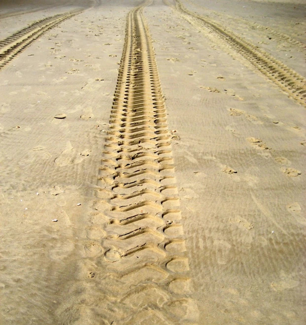 the tire prints in the sand are pointing up