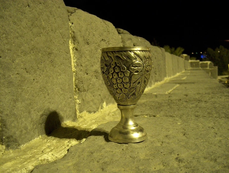 a ss trophy sitting next to a wall on the side walk