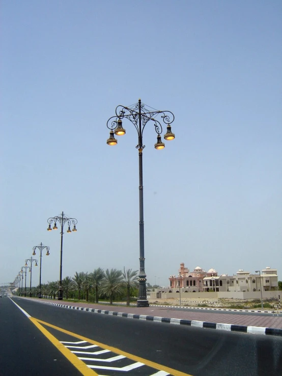 street lights are standing beside an empty road