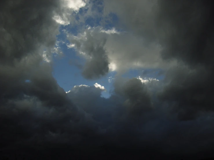 dark clouds move about in the sky above the water