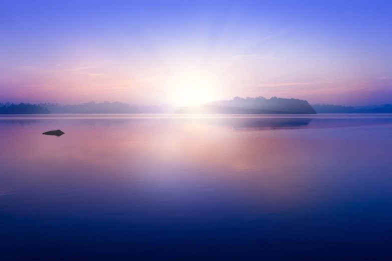 the sun is rising over an island on a calm lake