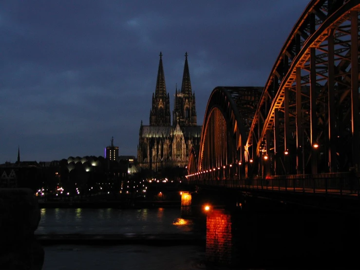 a bridge spanning the width of a river in front of a cathedral