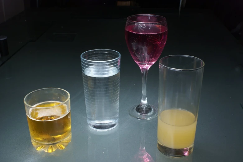 three glasses with different colored liquids in them