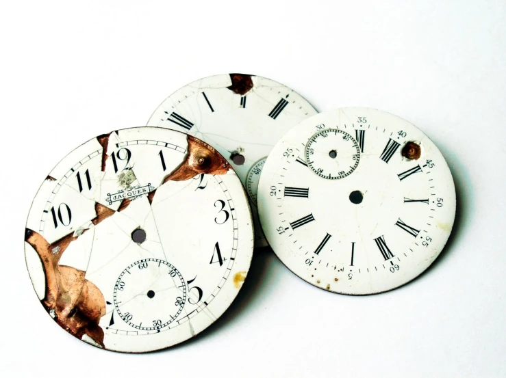 the two clock faces have been scratched into with paint