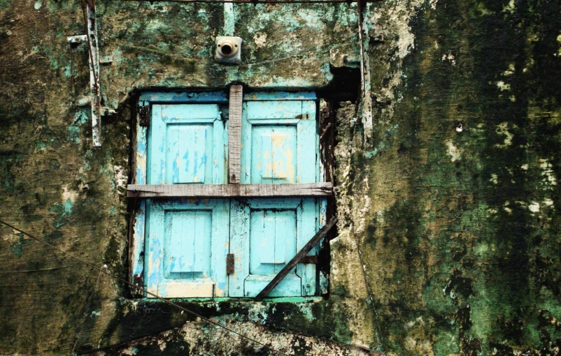 a blue door that is in between a wall and another