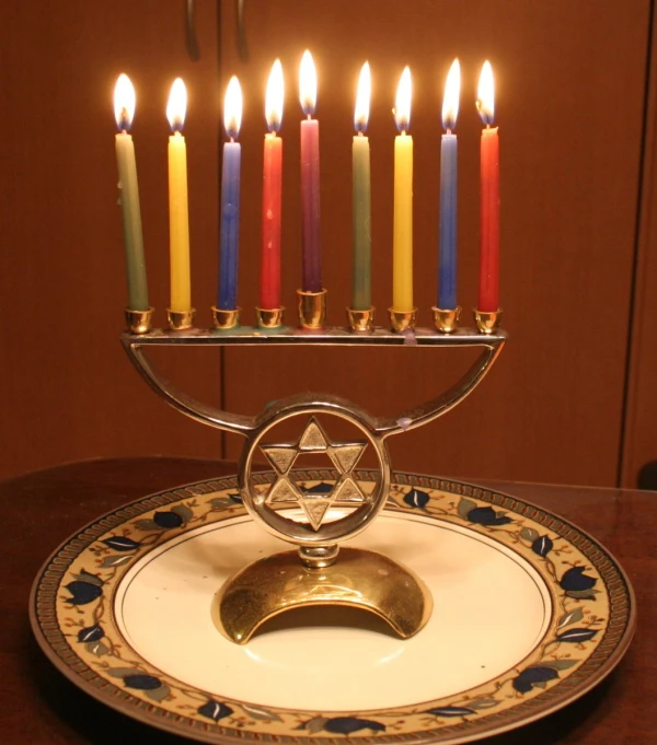 lit candle holders sit on a plate with a golden stand