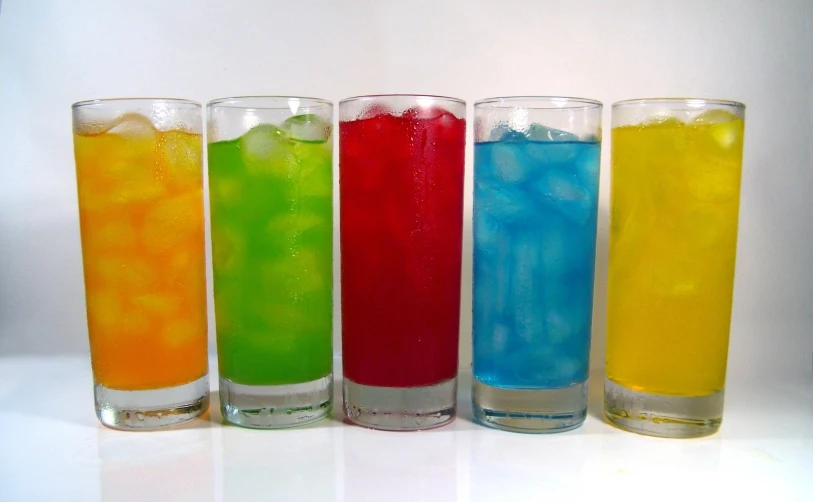 three s glasses of different flavored juice with ice