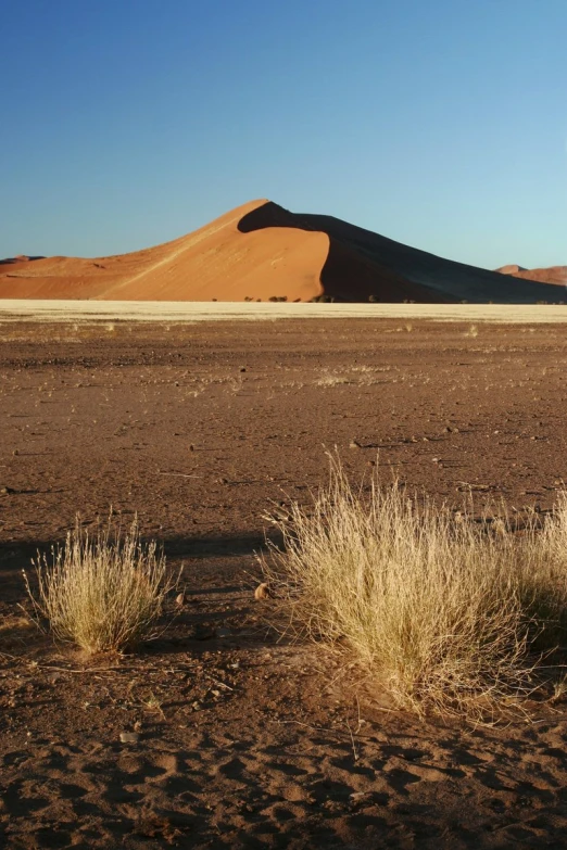 a desert with large hills and sp grass