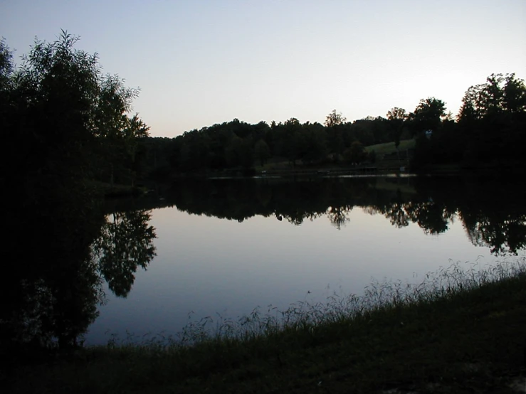 a body of water near a grassy hillside