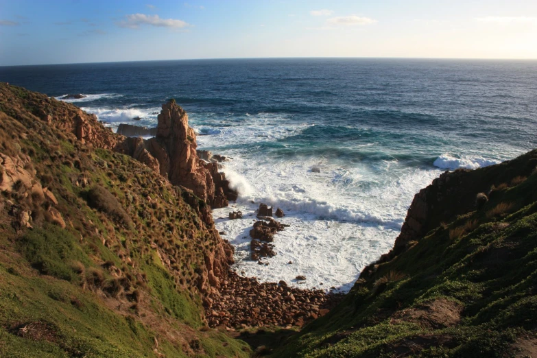 a very steep cliff beside some big body of water