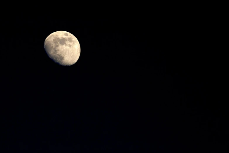 a large white moon is in the dark sky
