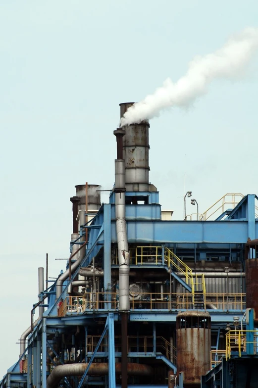 a view of pipes and smoke coming out of a pipe stack