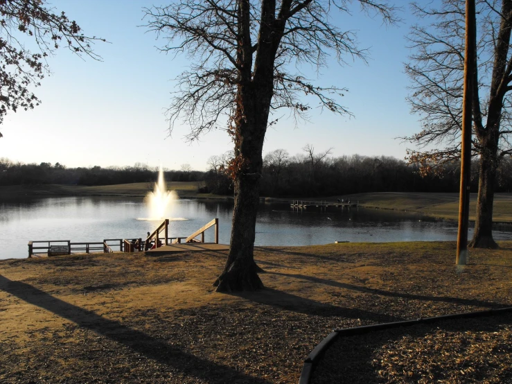 a scenic view of a park bench next to the lake