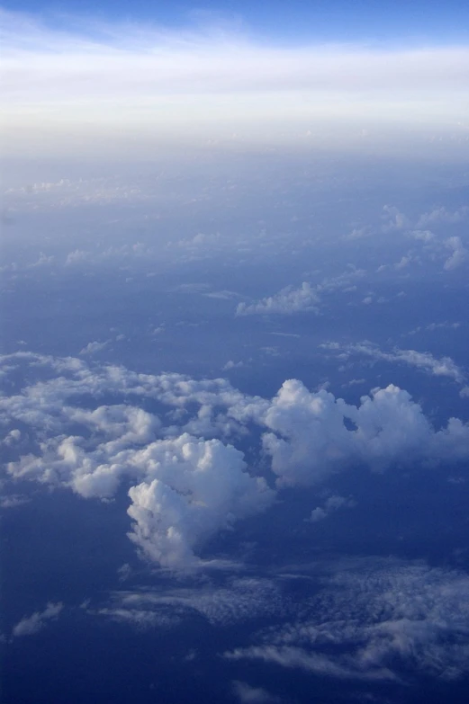 an airplane flies above clouds below the clouds