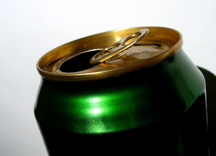 a close up of a green and gold metal can