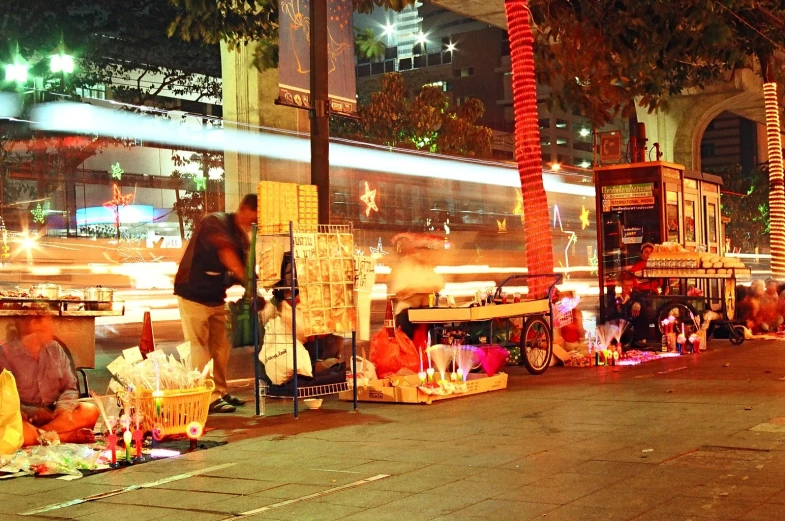 people sitting on the side walk at night