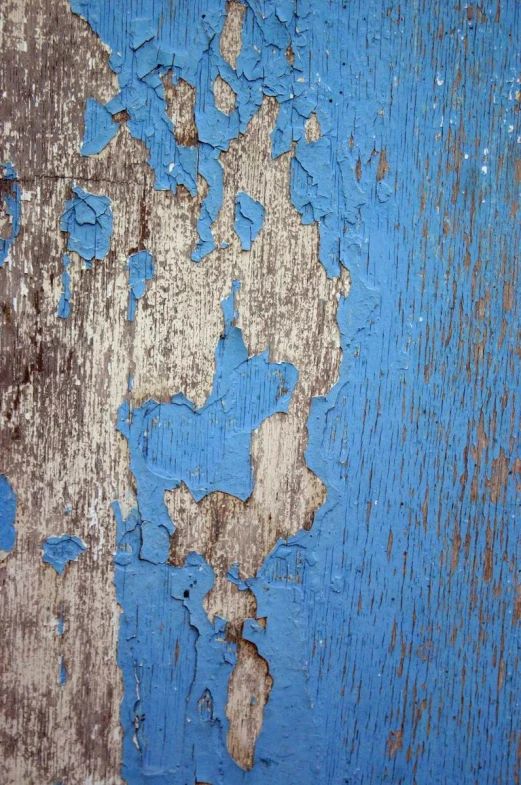 a paint chipped surface with peeling and fading blue