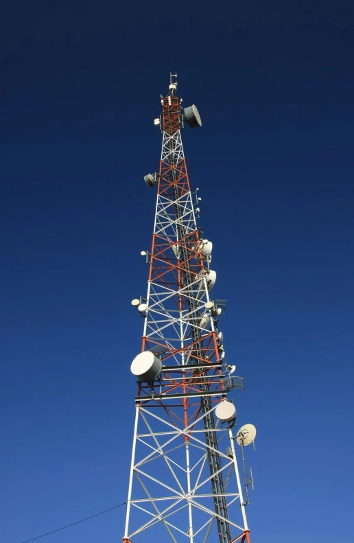 a radio tower on top of a field with a blue sky