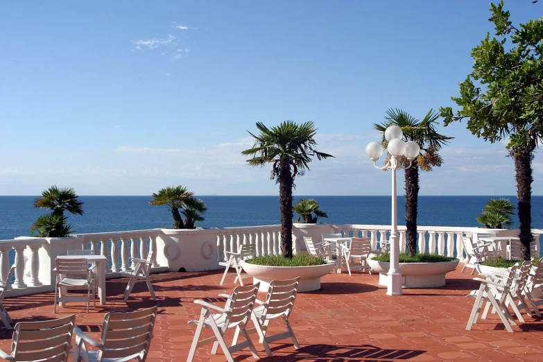 chairs are arranged outside on the side of the deck overlooking the ocean