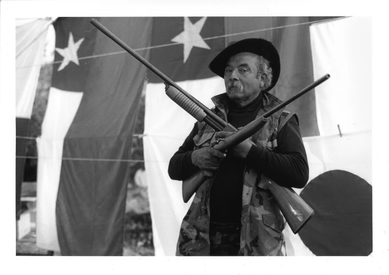 a black and white po of a man holding some guns