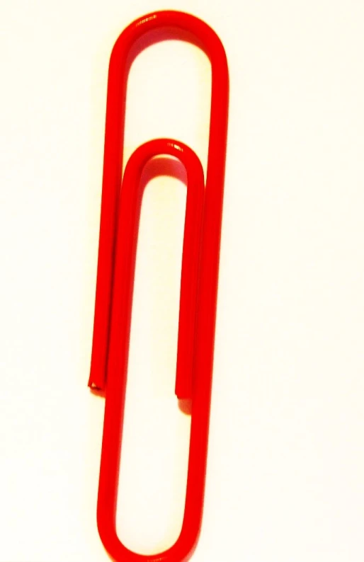 a close up of a red metal object on a white surface