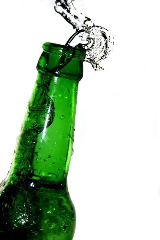 a green glass beer bottle with water coming from the top