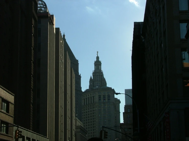 a tall clock tower stands above a city with other buildings