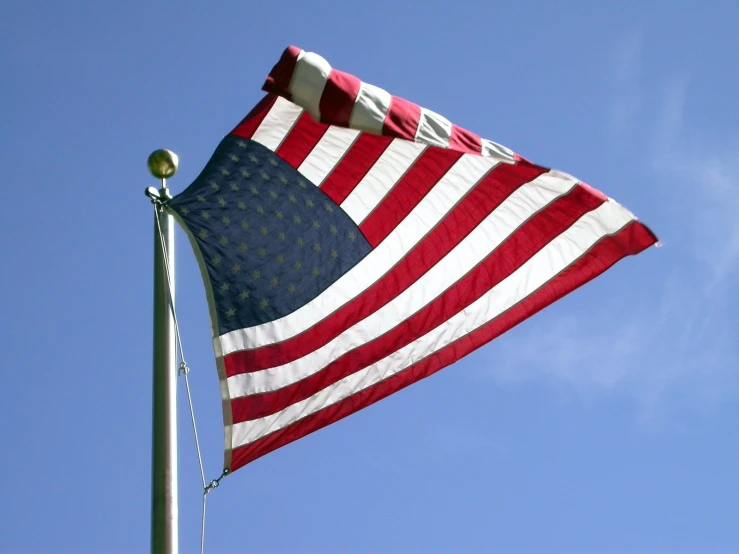 an american flag is fluttering on a tall pole