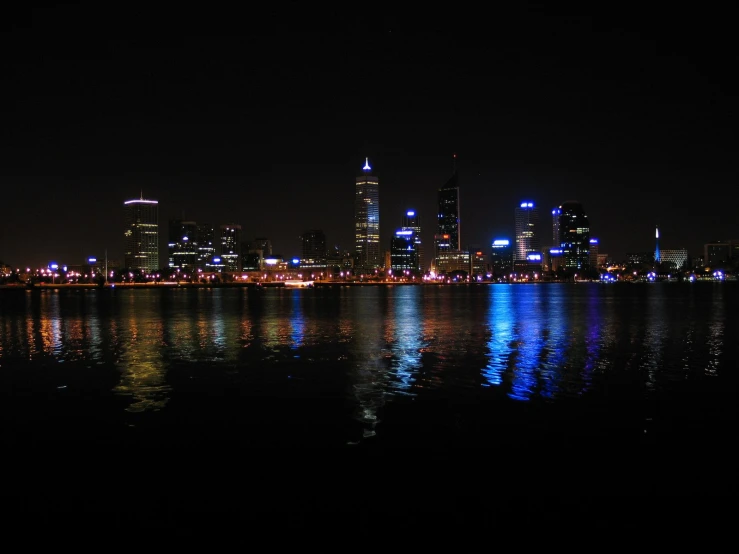 a city skyline at night over a lake