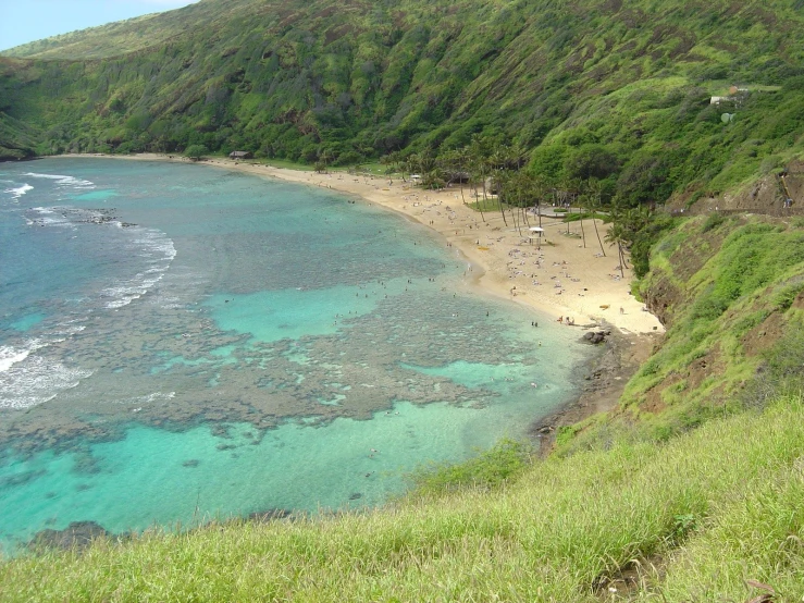 view of sandy beach with green hills and the ocean