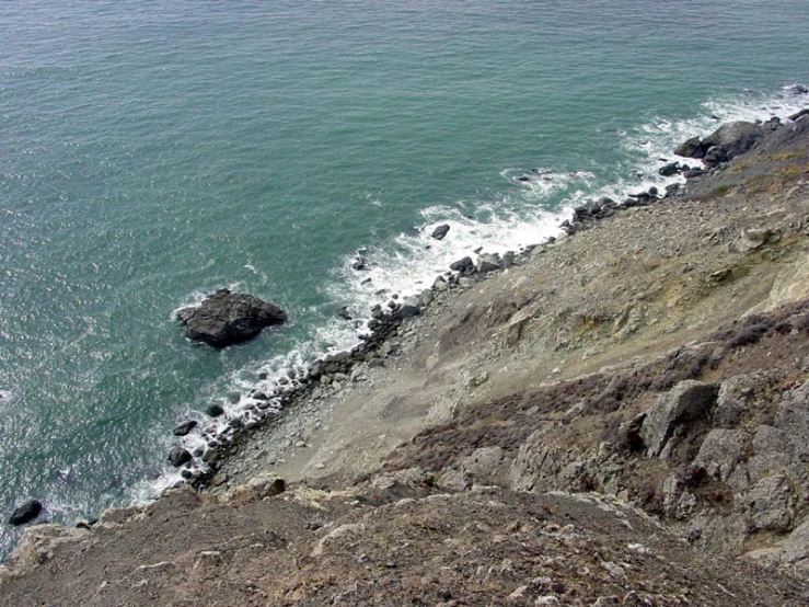 a man on top of a cliff overlooking a body of water