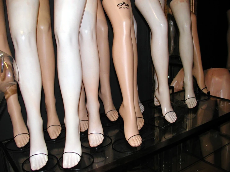 several mannequins are on a glass shelf
