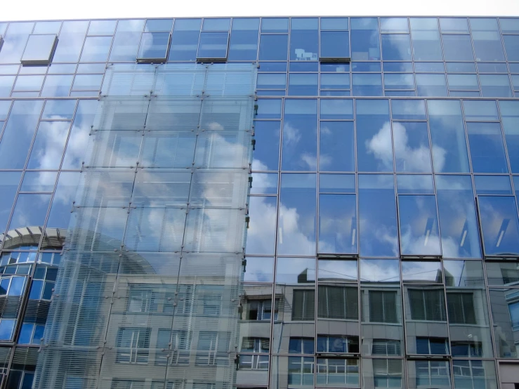 the reflection of clouds in a glass building