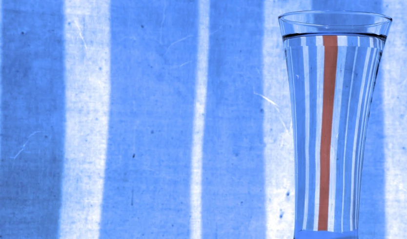 an elegant vase sitting on a table next to a wall