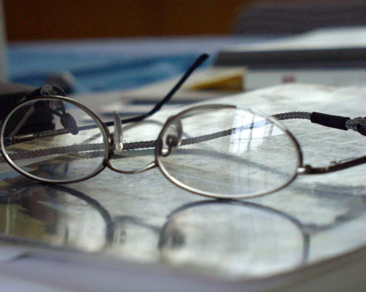 a pair of glasses that are sitting on top of some papers