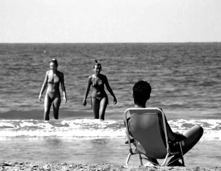 four women walking and standing in the ocean