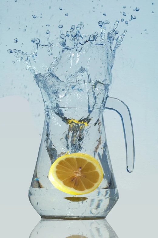 a yellow lemon wedge and a glass water pitcher