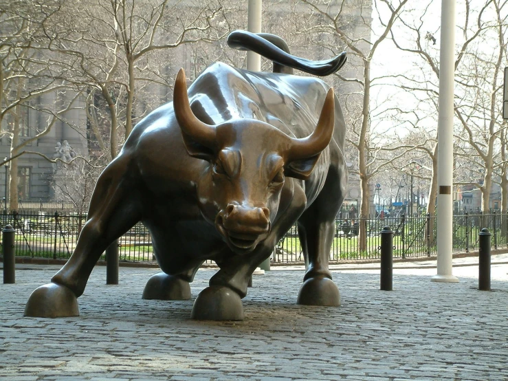 a metal statue of an animal running through the street