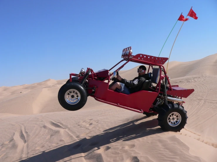 a man driving an off road buggy in the desert