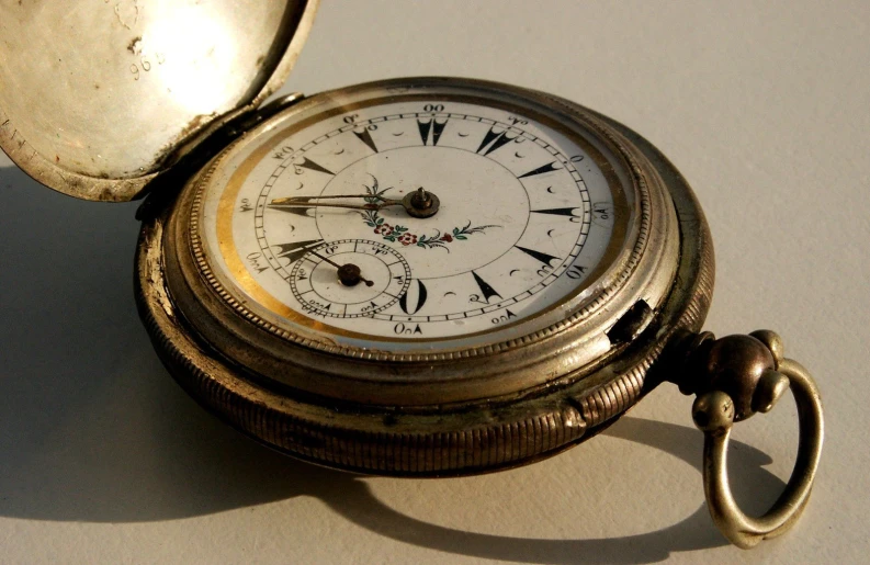 an old pocket watch is displayed on the table