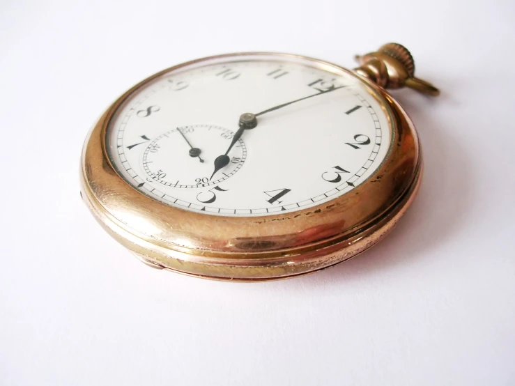 a close up of a gold pocket watch