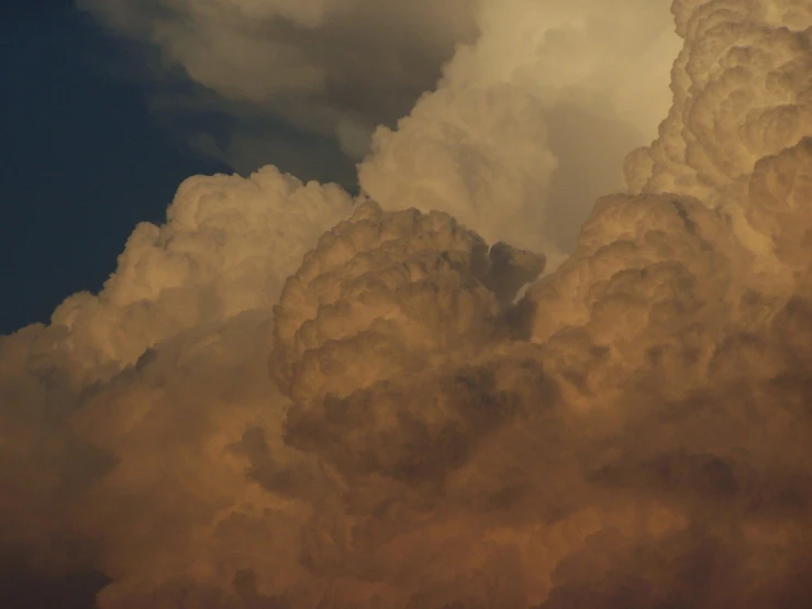 a plane flying through the clouds during the day