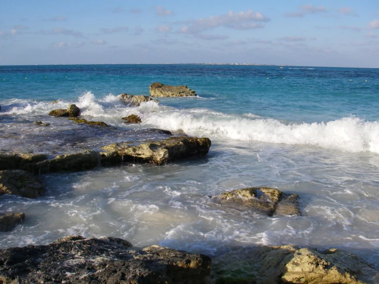 a wave is crashing on some rocks in the water