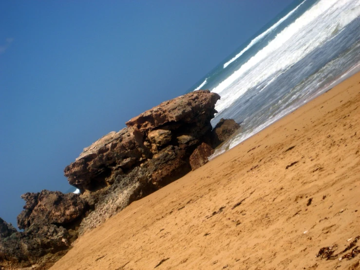 a sandy beach is surrounded by large rocks